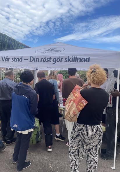 Människor samlade under Helsingborgspartiets tält vid ett utomhusevenemang.